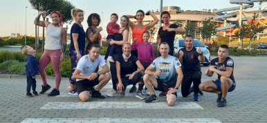Grupa sportowców przed Parkiem Wodnym Trzy Fale
